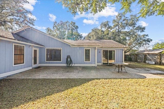 back of property with a lawn and a patio area