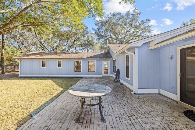 rear view of house featuring a patio area and a yard