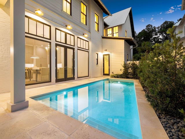 view of swimming pool featuring french doors and a patio area