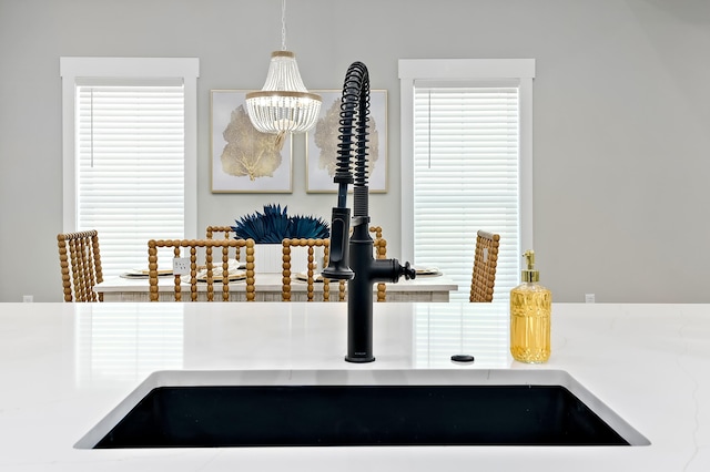 interior details featuring pendant lighting, a notable chandelier, and sink