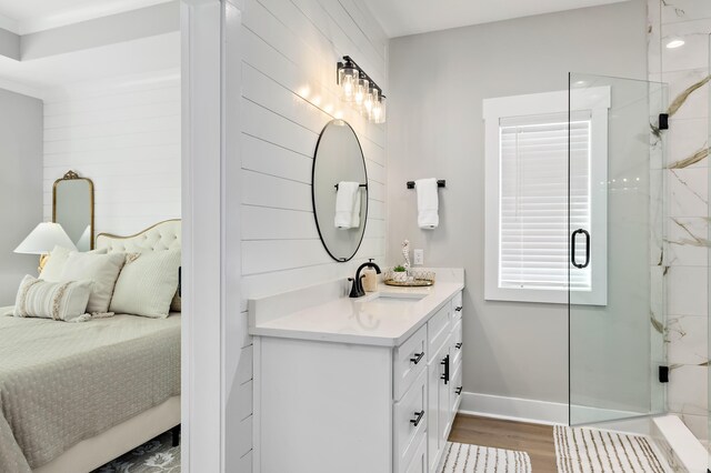 bathroom with hardwood / wood-style flooring, vanity, and a shower with shower door