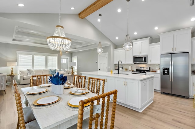 dining space with vaulted ceiling with beams, sink, a chandelier, and light wood-type flooring