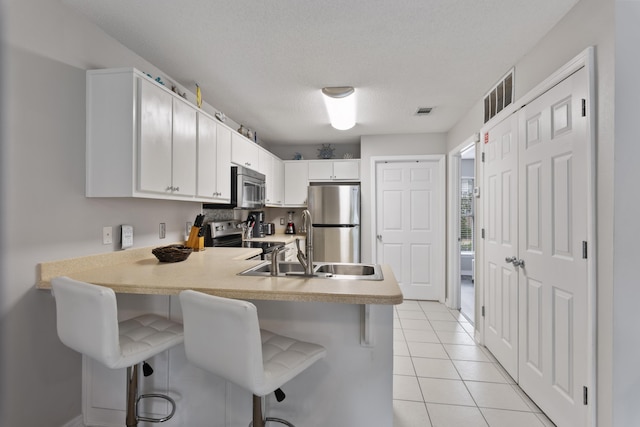 kitchen with kitchen peninsula, a kitchen breakfast bar, and stainless steel appliances