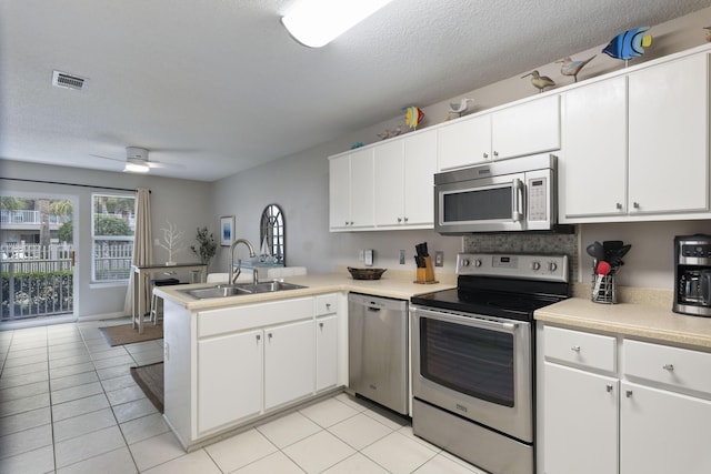 kitchen featuring white cabinets, kitchen peninsula, sink, and appliances with stainless steel finishes