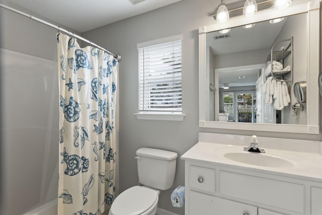 bathroom with vanity, a healthy amount of sunlight, and toilet