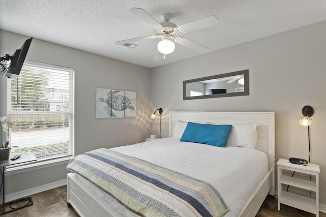 bedroom featuring a textured ceiling, ceiling fan, and dark wood-type flooring