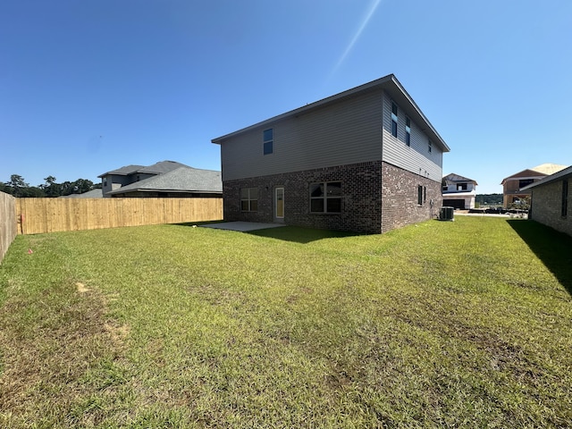 back of property featuring a lawn, cooling unit, and a patio area