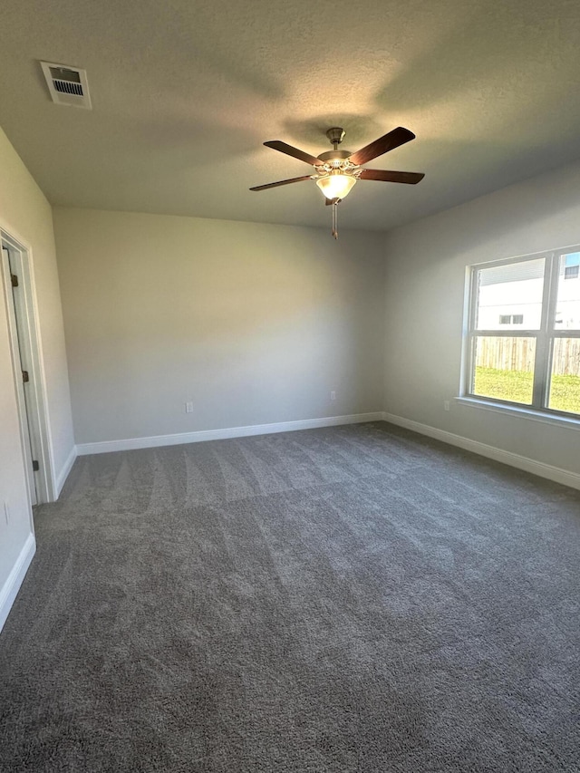 carpeted spare room featuring ceiling fan and a textured ceiling