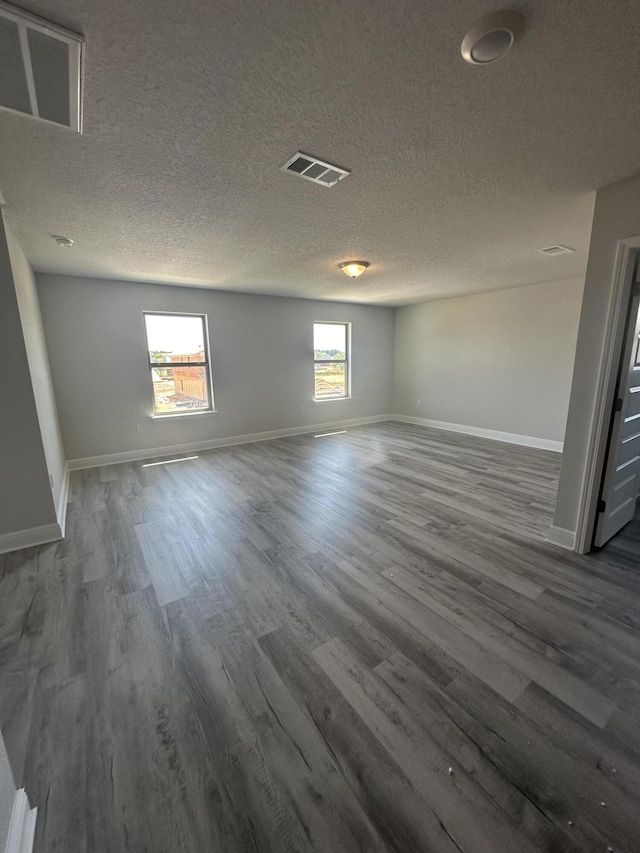 empty room featuring hardwood / wood-style flooring, plenty of natural light, and a textured ceiling