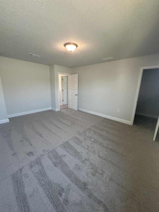 carpeted spare room with a textured ceiling