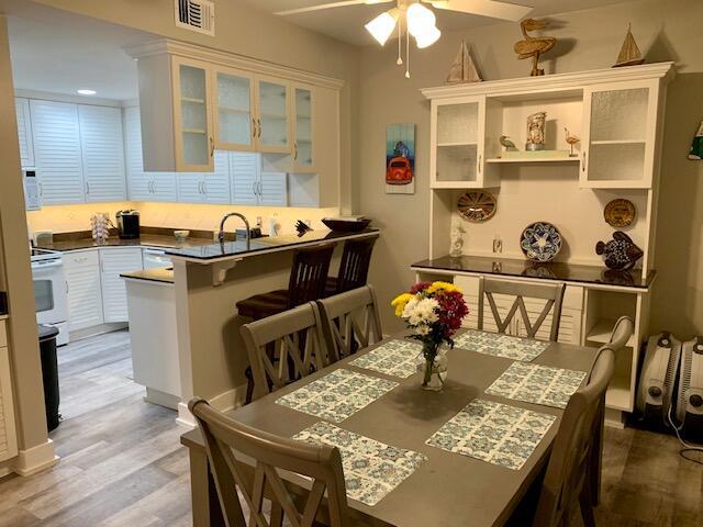 dining room with hardwood / wood-style flooring, ceiling fan, and sink