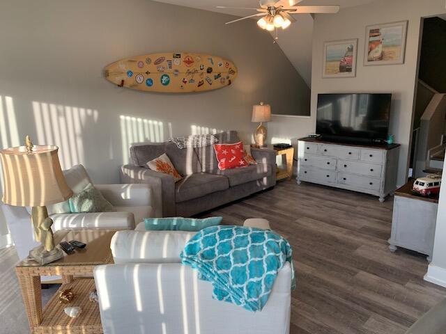 living room with vaulted ceiling, ceiling fan, and dark hardwood / wood-style floors