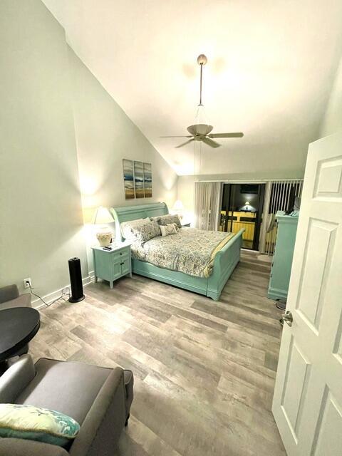 bedroom featuring ceiling fan, lofted ceiling, and hardwood / wood-style flooring