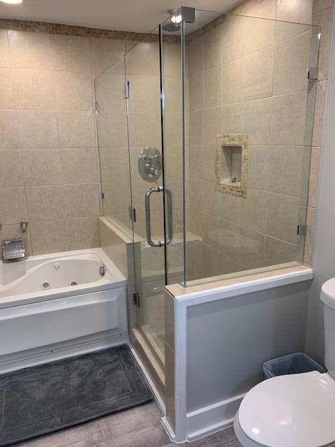 bathroom featuring separate shower and tub, hardwood / wood-style flooring, and toilet