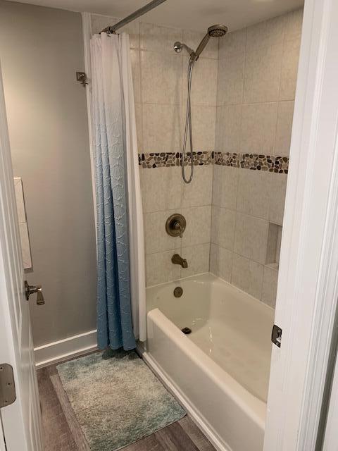 bathroom with hardwood / wood-style floors and shower / tub combo