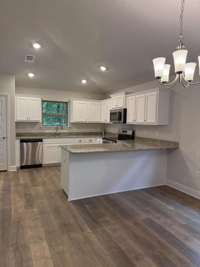 150 Ridgeway Cir, Crestview, FL 32536 - kitchen featuring stainless steel appliances, dark wood finished floors, white cabinetry, a chandelier, and a peninsula