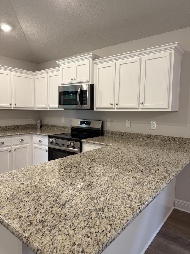 150 Ridgeway Cir, Crestview, FL 32536 - kitchen featuring stainless steel appliances, white cabinets, dark wood-type flooring, light stone counters, and a textured ceiling