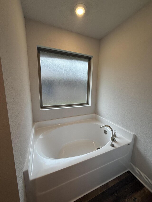 150 Ridgeway Cir, Crestview, FL 32536 - full bathroom featuring a garden tub, wood finished floors, and a textured wall