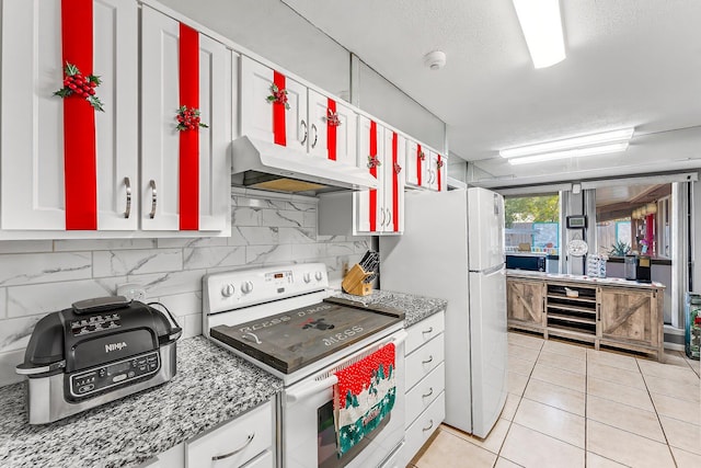 kitchen with stone countertops, white appliances, white cabinets, and light tile patterned flooring