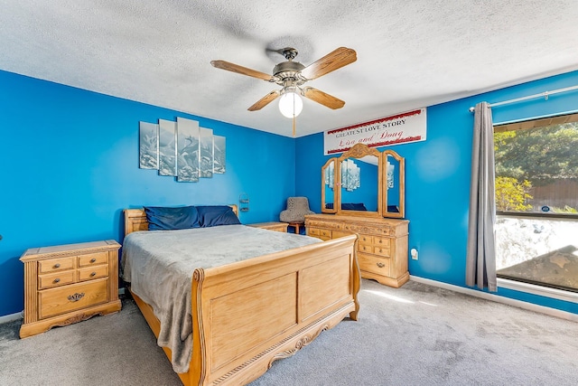 carpeted bedroom with ceiling fan and a textured ceiling