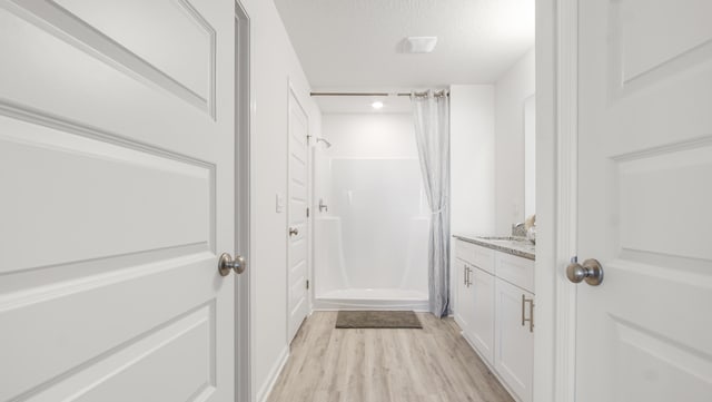 bathroom featuring hardwood / wood-style flooring, a textured ceiling, vanity, and a shower with shower curtain