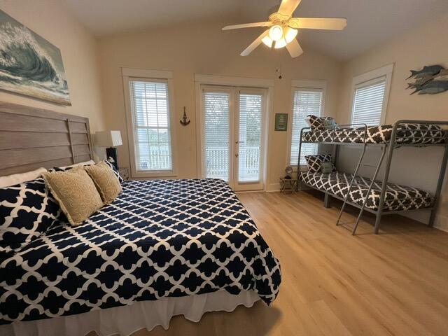 bedroom featuring access to outside, ceiling fan, vaulted ceiling, and hardwood / wood-style flooring