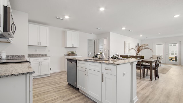 kitchen featuring sink, a kitchen island with sink, light stone countertops, stainless steel appliances, and white cabinets