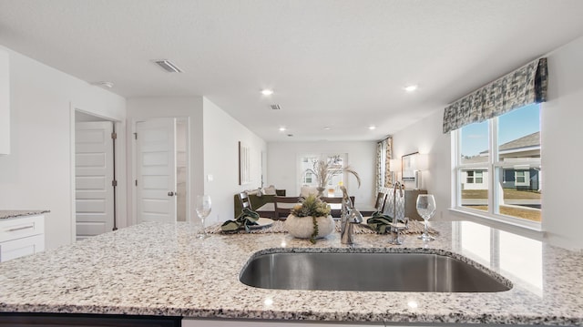 kitchen with light stone countertops and sink