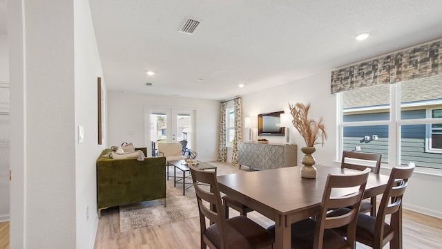 dining room featuring french doors and light hardwood / wood-style flooring