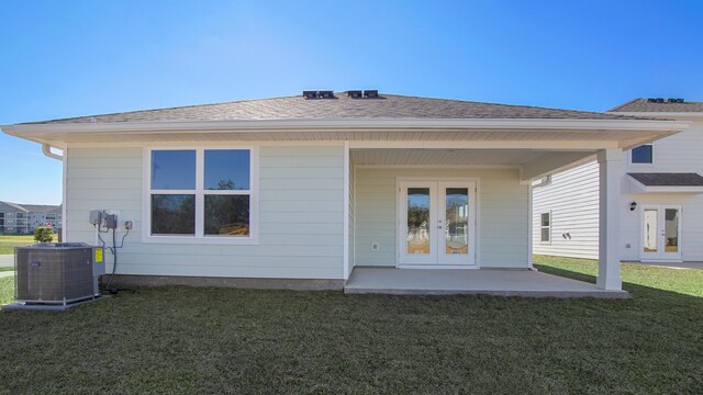 rear view of house with central AC, french doors, a patio, and a yard