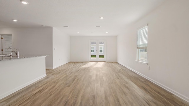 unfurnished living room featuring light wood-type flooring and sink