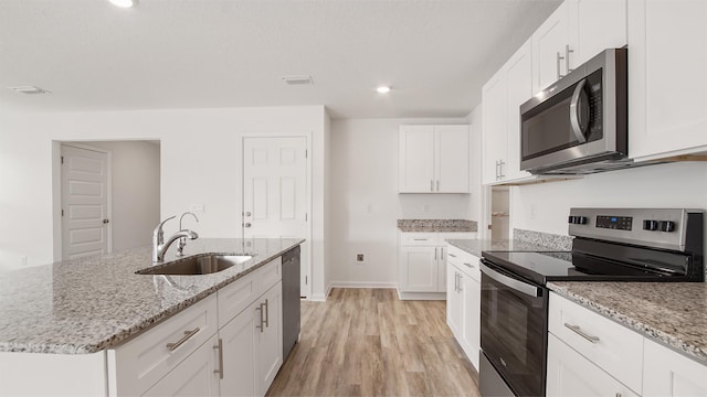 kitchen featuring stainless steel appliances, white cabinetry, and sink