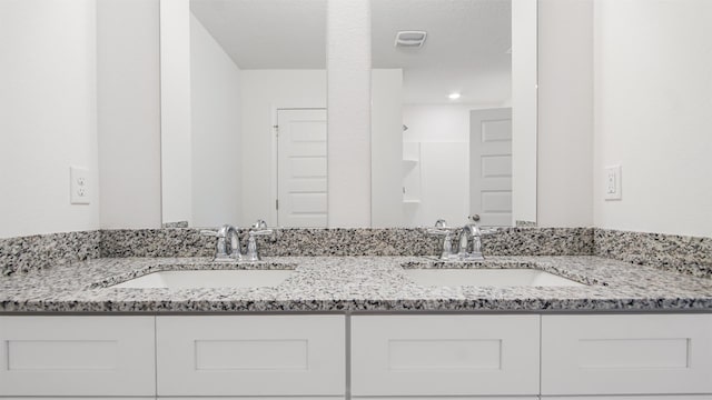 bathroom featuring walk in shower and vanity