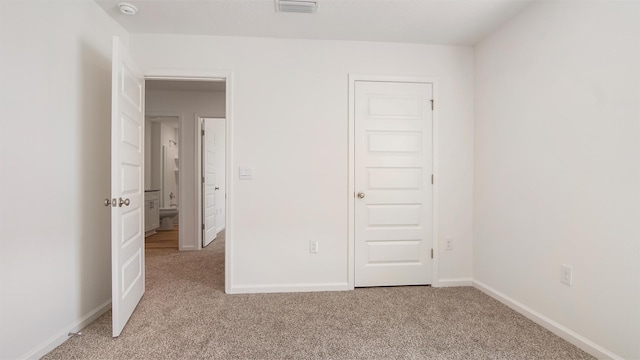 unfurnished bedroom featuring light carpet