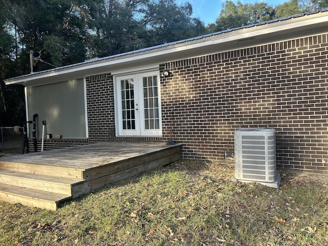 entrance to property featuring french doors, cooling unit, and a wooden deck