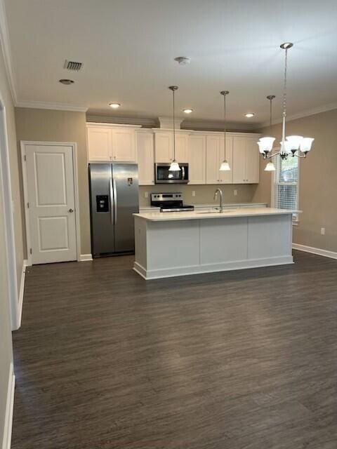 kitchen featuring white cabinetry, a center island with sink, decorative light fixtures, and appliances with stainless steel finishes