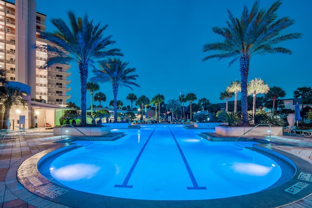 pool at night with a patio area