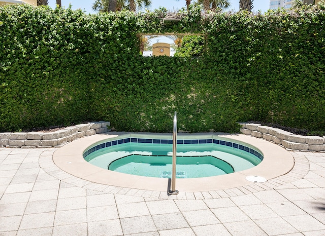 view of swimming pool with an in ground hot tub