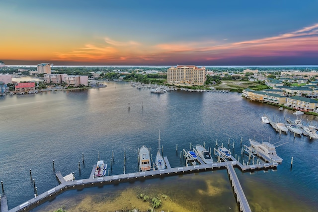 aerial view at dusk featuring a water view