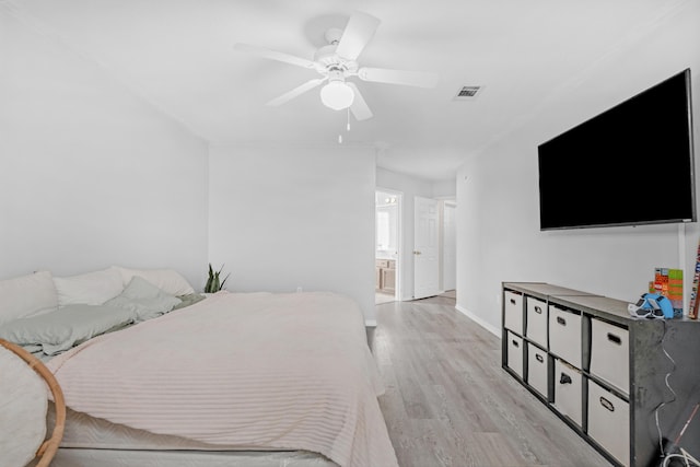 bedroom with ceiling fan, light wood-type flooring, and ensuite bath