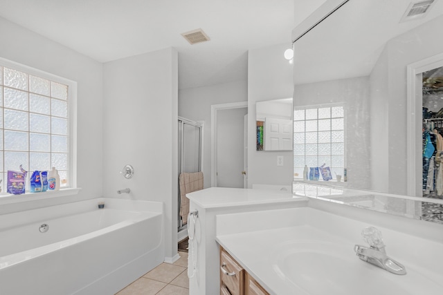 bathroom with tile patterned flooring, plenty of natural light, separate shower and tub, and vanity