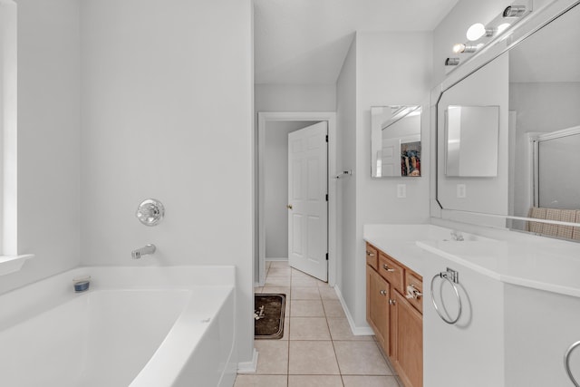 bathroom with a washtub, vanity, and tile patterned floors