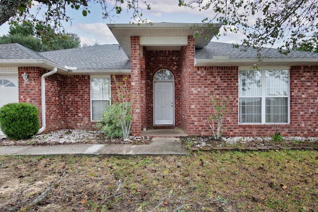 664 Brunson St, Crestview, FL 32536 - property entrance featuring roof with shingles, brick siding, and a garage