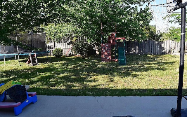 view of yard with a playground and a trampoline