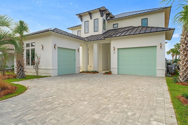 view of front of home featuring a garage and central air condition unit