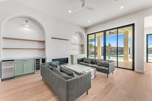 living room featuring ceiling fan, light hardwood / wood-style floors, and beverage cooler