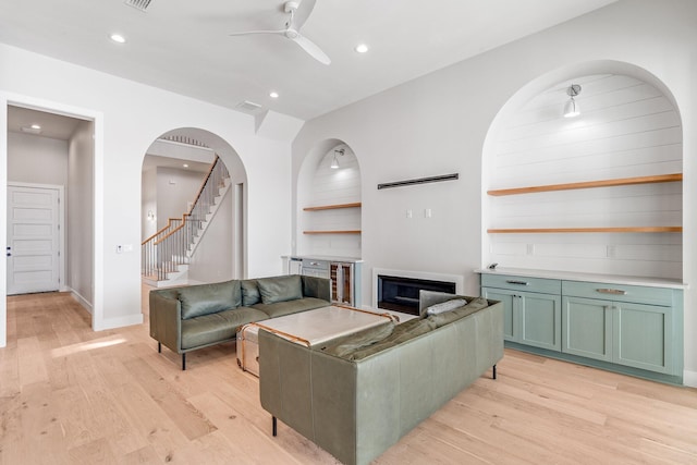 living room featuring light hardwood / wood-style flooring and ceiling fan