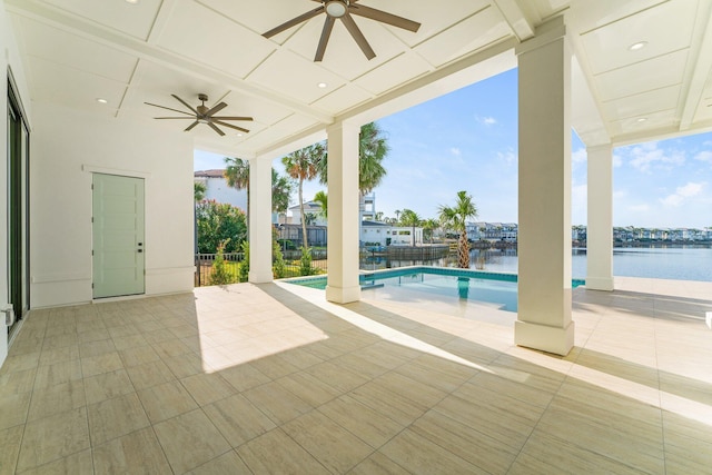 view of pool with ceiling fan, a water view, and a patio