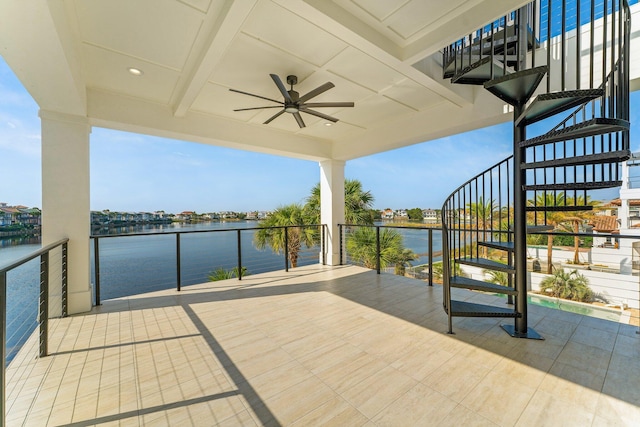 view of patio with a water view and ceiling fan