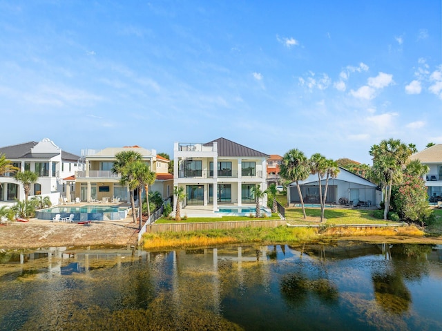 rear view of house featuring a patio area, a balcony, and a water view